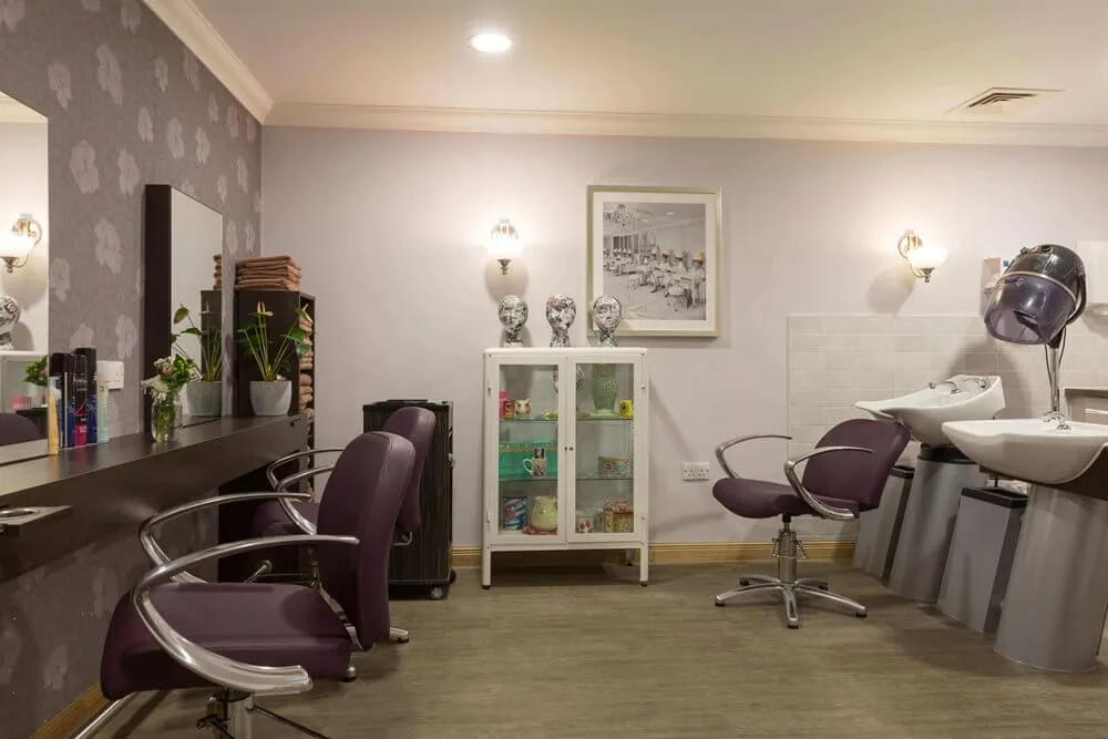 The hair and beauty salon at Sherwood Grange, with styling chairs, basins and a dryer hood